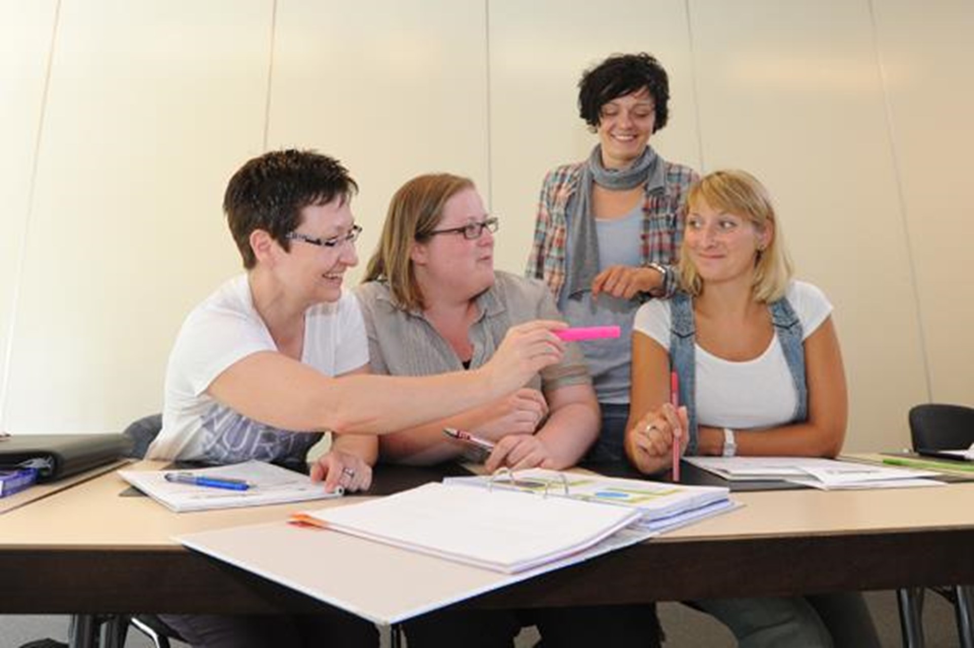 Vier Frauen sitzen an einem Schreibtisch und diskutieren